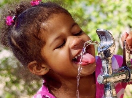 Little girl drinking from water fountain
